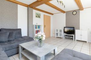 a living room with a couch and a table with flowers at Ferienhaus Neeb in Gammendorf