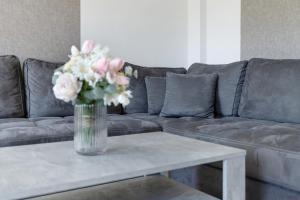 a vase of flowers on a table in front of a couch at Ferienhaus Neeb in Gammendorf