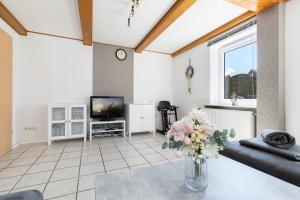 a living room with a vase of flowers on a table at Ferienhaus Neeb in Gammendorf +36 photos