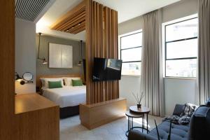 a hotel room with a bed and a television at The Shell House in Tel Aviv