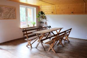 a dining room with a wooden table and chairs at Chata Romanka in Sopotnia Mała