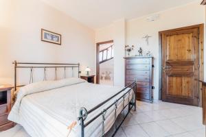 a bedroom with a bed and a dresser and a door at Il Falco del Cilento in Torchiara +12 photos