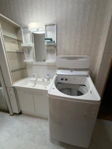 a small bathroom with a toilet and a sink at 雅ストリートハウス角館 in Senboku