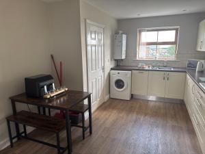 a kitchen with a sink and a washing machine in it at Thornley pit house farm in Durham