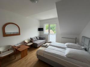 a bedroom with a bed and a couch and a table at Tedi 2 in Rewal