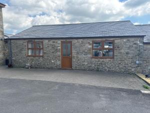a brick house with a brown door and windows at Thornley pit house farm in Durham