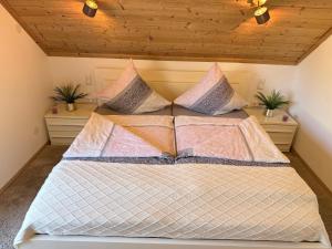 a bedroom with a bed with pillows at Fichtelfeeling in Fichtelberg
