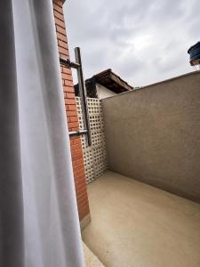 an open door to a balcony with a brick wall at Loft Novo, Duplex, bem ventilado in Aparecida de Goiânia +2 photos