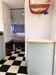 a kitchen with a refrigerator and a checkered floor at Przyczepa Kite Jastarnia blisko Zatoki Loop it in Jastarnia