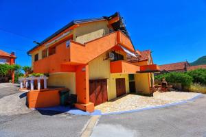 a house with an orange staircase on the side of it at Holiday Home Rocca with pool in Vrgorac