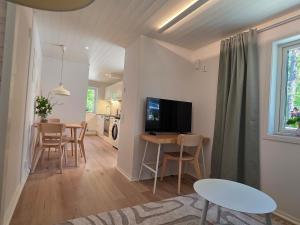 a living room and dining room with a television and a table at Lyckebo in Tyresö