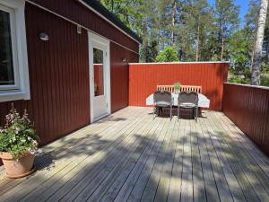 a wooden deck with two chairs and a table at Lyckebo in Tyresö