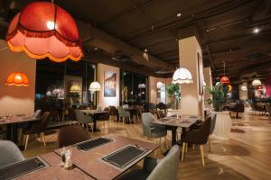 a restaurant with tables and chairs in a room at M Hotels at Porto Marina in El Alamein