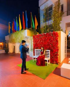 a man taking a picture of a woman sitting on a bench at Grand Mostafa Hotel in Sylhet