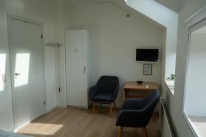 a room with two chairs and a desk and a tv at Motel Stege in Stege