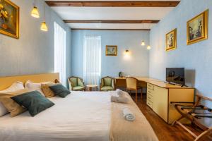 a hotel room with a bed and a desk and a television at Cherry Tree Sibiu in Sibiu