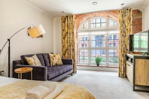 a living room with a couch and a large window at York Cocoa Suites - city centre apartments in York
