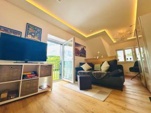 a living room with a large flat screen tv at Komfort-Fewo mit Infrarotsauna & WLAN nahe Sorpesee - Haus am Krähenbach - Steinert in Sundern