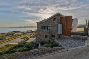 a brick building with the ocean in the background at Μαυρόλιθος in Karistos
