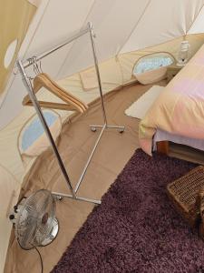 a bedroom with a tent with a fan and a rug at Torpakka glamping in Mikkeli +23 photos