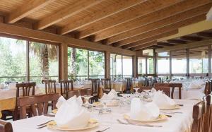 a dining room with white tables and chairs and windows at Il Falco del Cilento in Torchiara