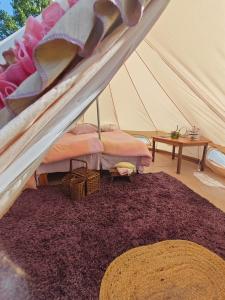 a bedroom with a tent with a bed and a rug at Torpakka glamping in Mikkeli