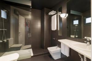 a bathroom with a sink and a toilet and a tub at Exe Hotel El Magistral in Oviedo