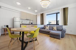 a living room with a table and a couch at Apartaments PopDan Residence by the Sea in Eforie Nord