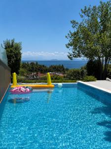 a swimming pool with an inflatable at Villa Magnifica - Private Pool, Elevator & Sea View in Paliouri