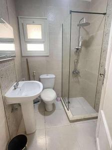 a bathroom with a toilet and a shower and a sink at شاليه مارسليا بيتش in Dawwār Muḩammad Abū Shanab
