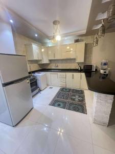 a kitchen with white cabinets and a refrigerator at شاليه مارسليا بيتش in Dawwār Muḩammad Abū Shanab