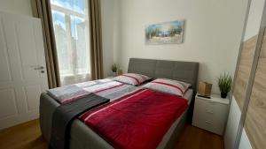 a bedroom with a bed with a red blanket at MEERzeit-Norderney in Norderney