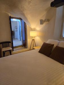 a bedroom with a bed and a mirror and a lamp at La Tour Noble in Saint-Saturnin