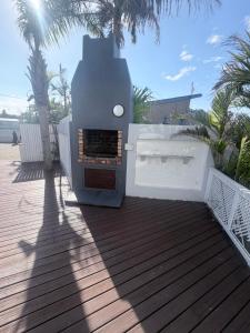 a outdoor grill on a deck with palm trees at CCV Beach House in Bay View