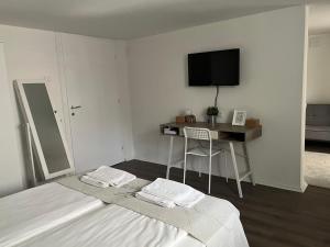 a bedroom with a bed and a desk and a television at Apartment Sneshka in Ohrid