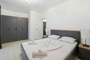 a bedroom with a large bed with towels on it at Apartaments PopDan Residence by the Sea in Eforie Nord