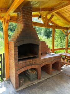 an outdoor brick oven with a wooden roof at Cabana Plai in Petroşani