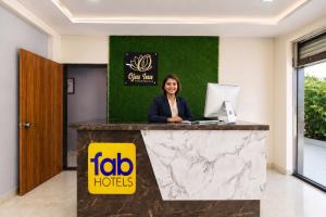 a woman sitting at a counter with a laptop at FabHotel Ojas Inn in Pune