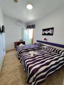 a group of three beds in a room at Hotel Restaurante Campomar in Cartagena