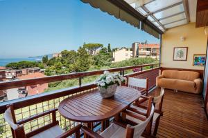 a balcony with a wooden table and chairs at Maison Panorama - Portofino View in Lavagna