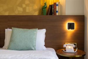 a hotel room with a bed with a phone on a table at Hotel Parc Eiffel in Paris