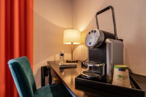 a hotel room with a desk with a lamp and a chair at Logis hotels Les Glycines in Melle