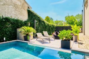 a patio with a pool and two chairs and plants at Villa Gio's in Monza