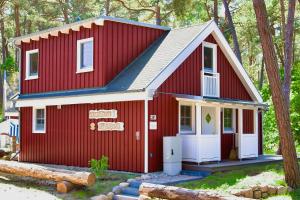 a red house with a white door in the woods at Strandhaus Rügenperle - Baabe in Baabe