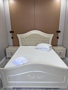 a white bed with two white towels on it at Жастар in Astana