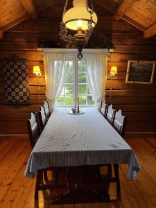 a dining room with a table and chairs and a window at Såmmårstuggu in Røros
