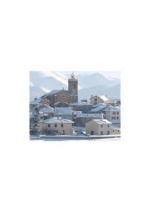 a town in the snow with a church in the background at Centre village, proche toutes commodités in Les Angles +2 photos