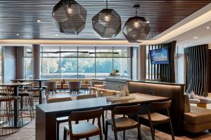 a restaurant with a bar with tables and chairs at SpringHill Suites by Marriott Sandusky in Sandusky