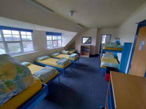 a room with several bunk beds in a classroom at Adventure Bude in Bude