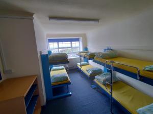 a room with four bunk beds and a window at Adventure Bude in Bude